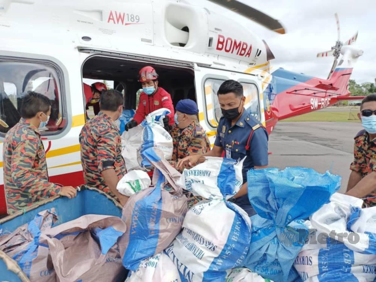 Pasukan JBPM Sarawak memunggah bantuan ke pesawat AW189 Agusta di Pengkalan Operasi Udara JBPM Miri sebelum dihantar ke mangsa banjir di Mulu, hari ini. FOTO ERIKA GEORGE