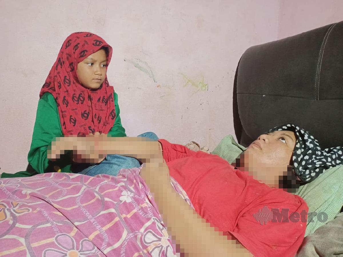 Nur Jasrin Elisya Mohd Zain, 9, menjaga ibunya.