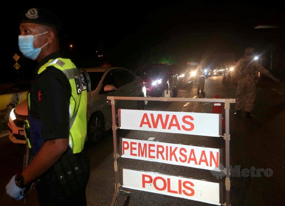 Anggota Polis Diraja Malaysia (PDRM) bersama anggota ATM membuat pemeriksaan Sekatan Jalan Raya (SJR) di Jalan Persiaran Kota berhadapan Bangunan MPK berikutan PKP bermula tengah malam ini sehingga 26 Januari. FOTO MUHD ASYRAF SAWAL