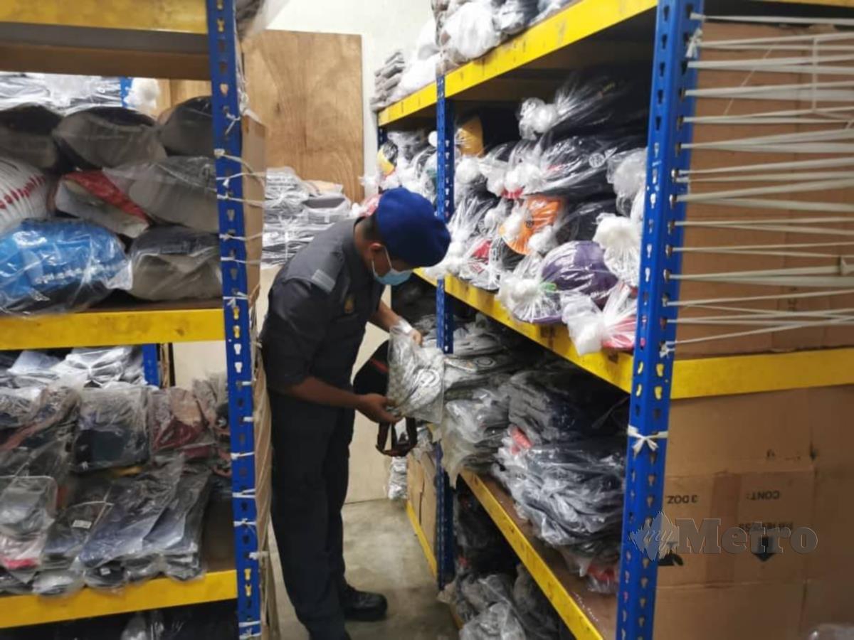  ANGGOTA penguatkuasa KPDNHEP Kuala Lumpur memeriksa barangan disyaki tiruan yang ditemui dalam serbuan di dua premis di Lorong Haji Taib dan Bandar Sri Damansara, Kuala Lumpur, kelmarin.