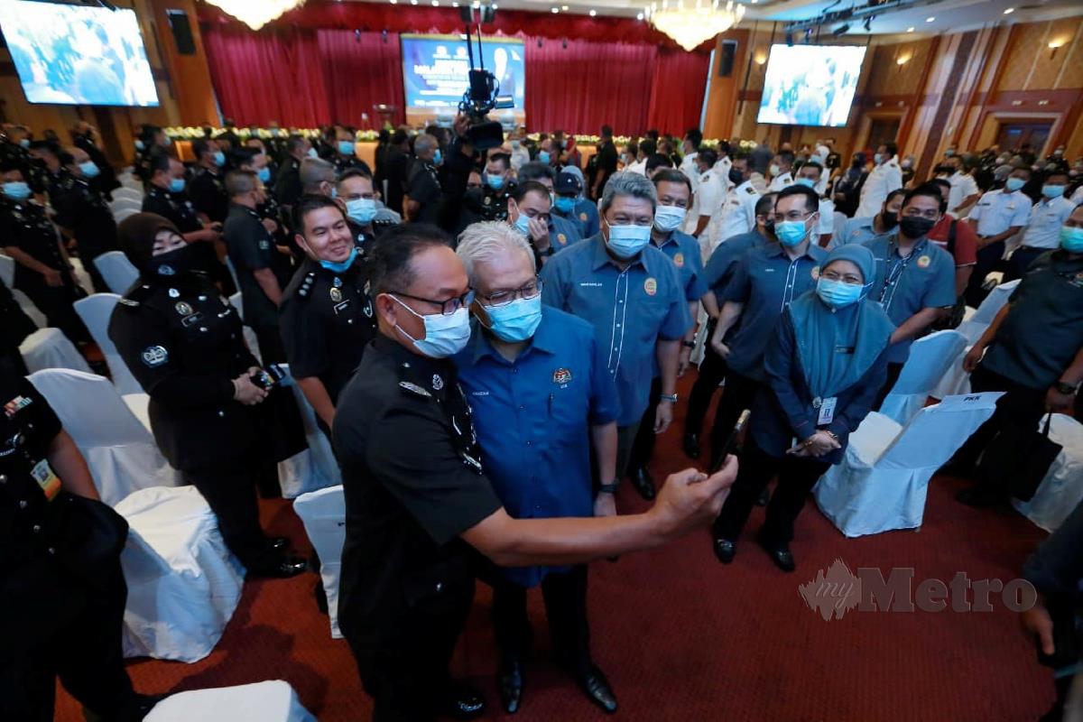 Hamzah Zainuddin swafoto bersama anggota polis yang hadir pada Program Malaysia Prihatin Kementerian Dalam Negeri di Dewan Banquet Bangunan Perak Darul Ridzuan. FOTO SHARUL HAFIZ ZAM