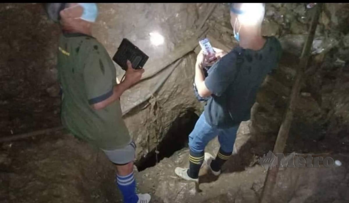 Rakan mangsa menunjukkan lokasi terowong di dalam gua di Gunung Tabai, yang runtuh. FOTO IHSAN JBPM