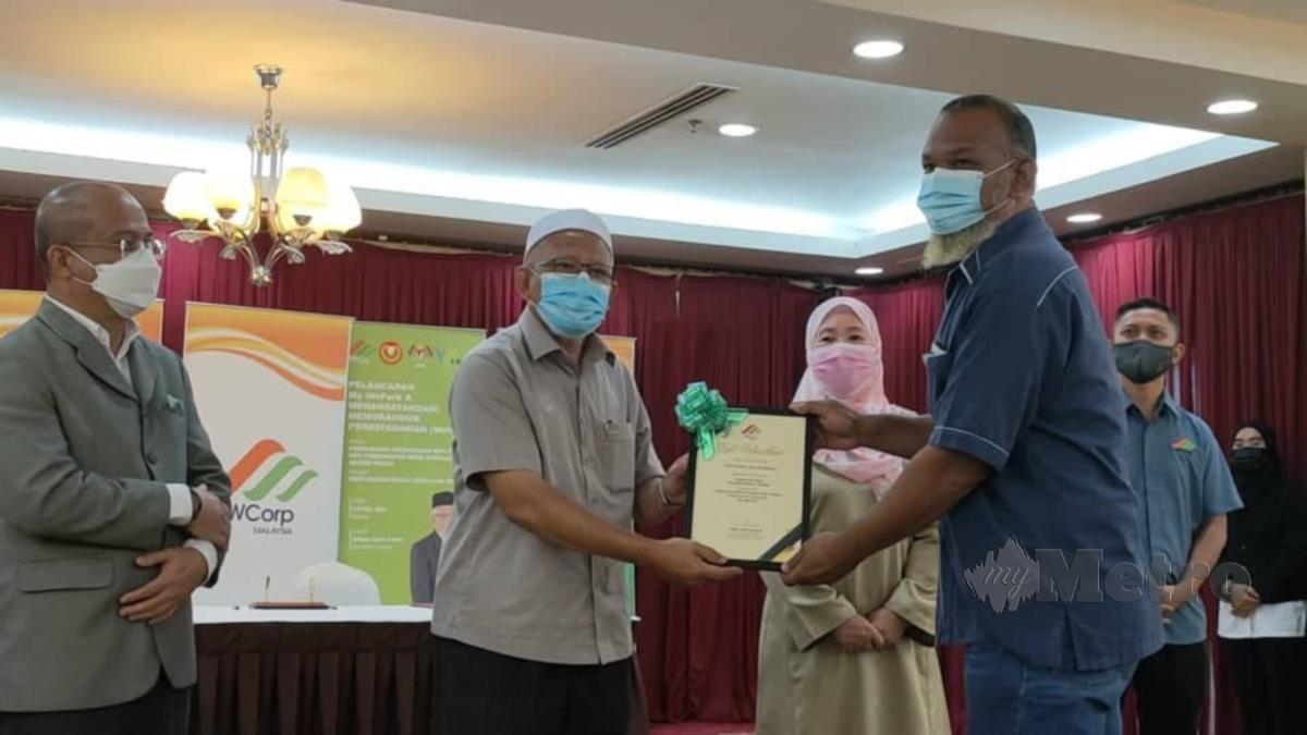 Mohd Hayati (tengah) menyerahkan sijil penghargaan kepada antara 12 pengerusi My iNsPark di Wisma Darul Aman. Foto Noorazura Abdul Rahman