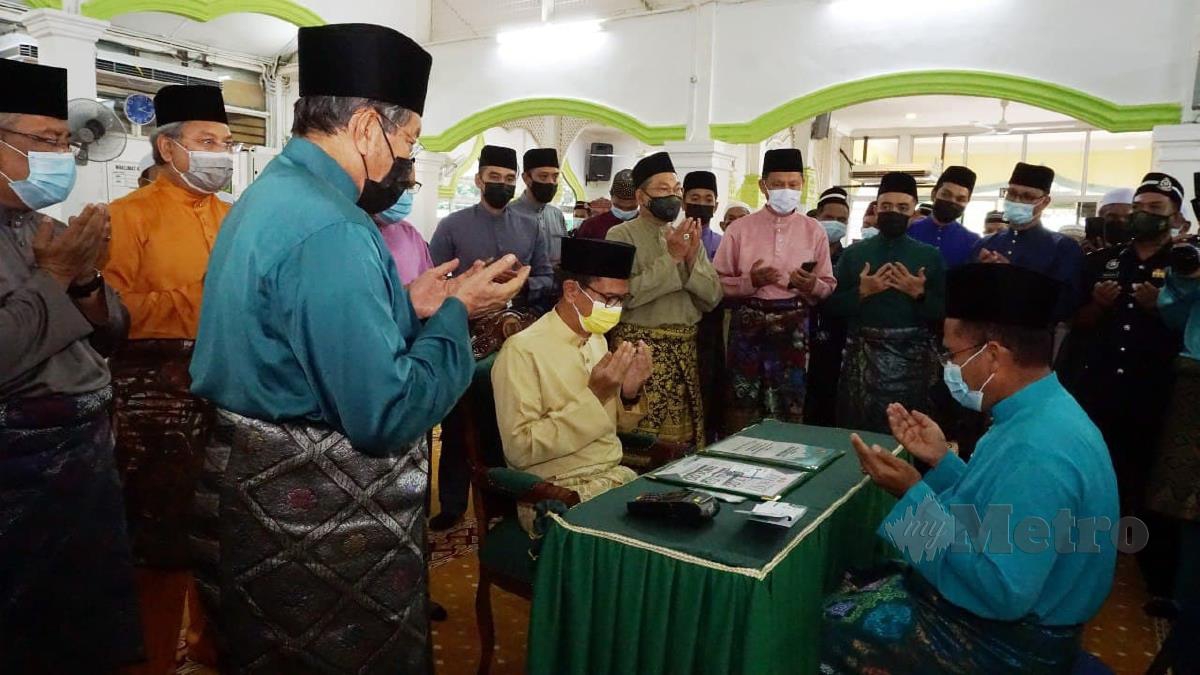 Fadzil Awang (kiri berdiri) memimpin bacaan doa selepas Tengku Sarafudin Badlishah selesai menunaikan zakat fitrah. Foto Noorazura Abdul Rahman