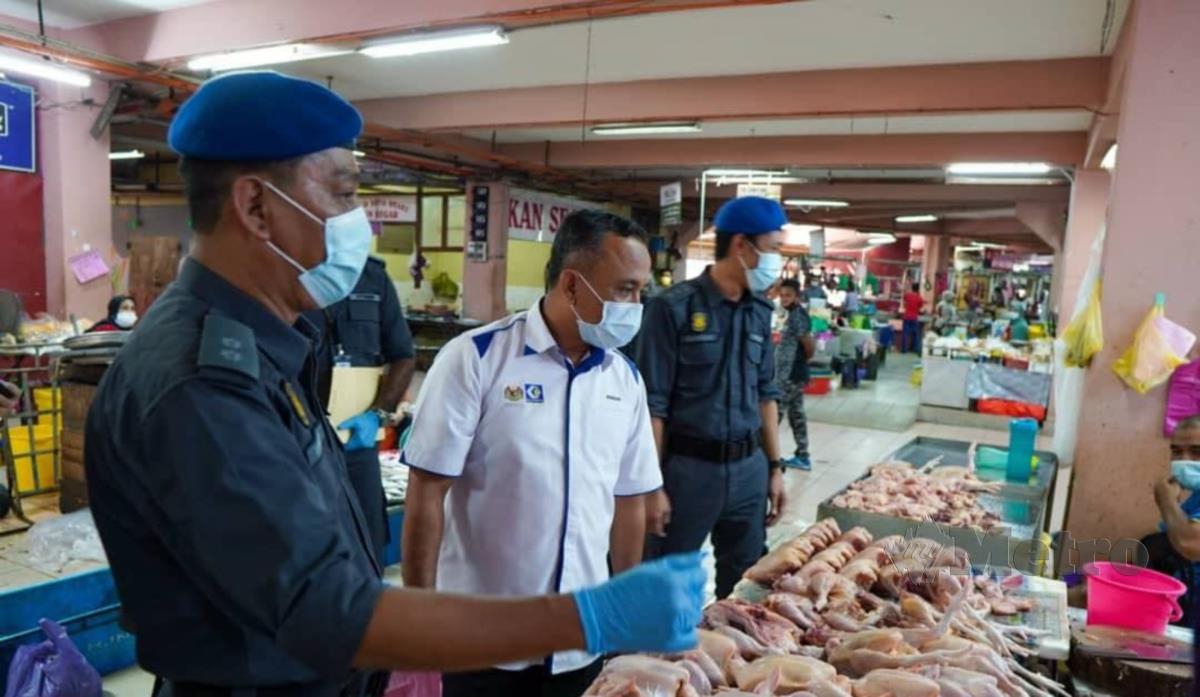 Adnan Abd Rahman (tengah) meninjau gerai peniaga ayam di Pasar Besar Siti Khadijah. FOTO IHSAN KPDNHEP