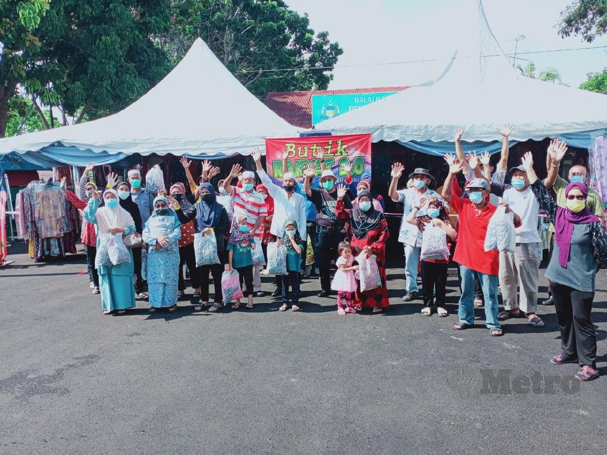 Pengerusi JPKK Klebang Besar, Datuk Mohd Yusof Abu Hassan (tengah berkopiah) bersama pengunjung yang mendapatkan pakaian percuma di Butik Rakyat, di Pulau Gadong, Melaka, hari ini. FOTO AMIR MAMAT
