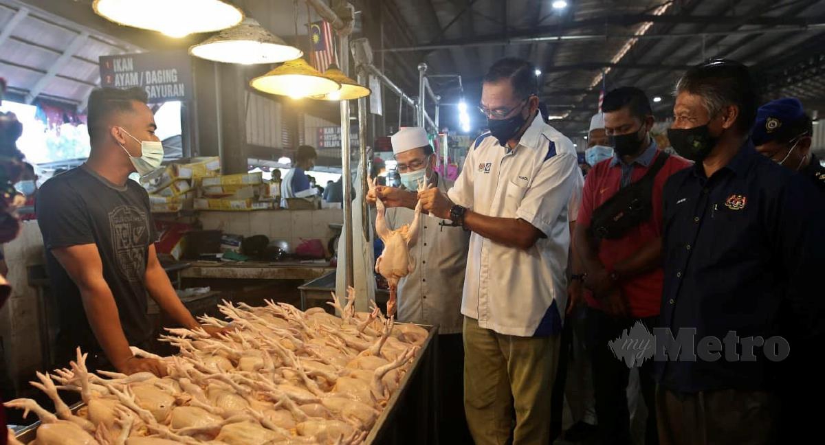 Rosol Wahid (tengah) meninjau harga sayur  ketika tinjauan di Pasar Chabang Tiga hari ini.  FOTO GHAZALI KORI