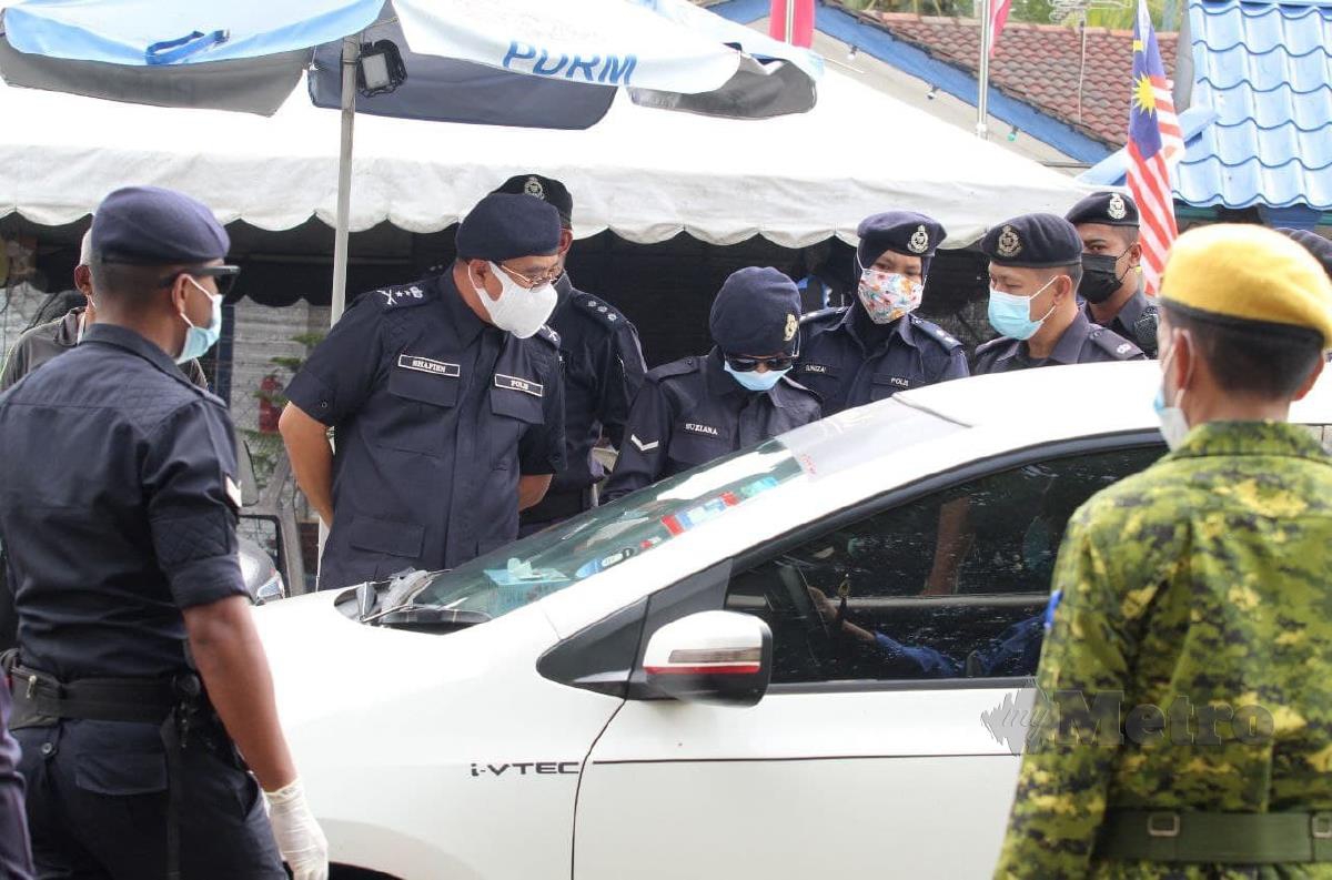 Anggota polis memeriksa dokumen perjalanan di SJR Bukit Yong. FOTO NIK ABDULLAH NIK OMAR