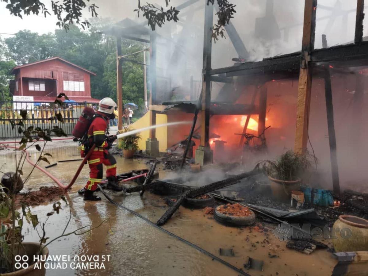 ANGGOTA bomba memadam kebakaran sebuah rumah di Kampung Bahagia, Teluk Intan. FOTO Ihsan JBPM