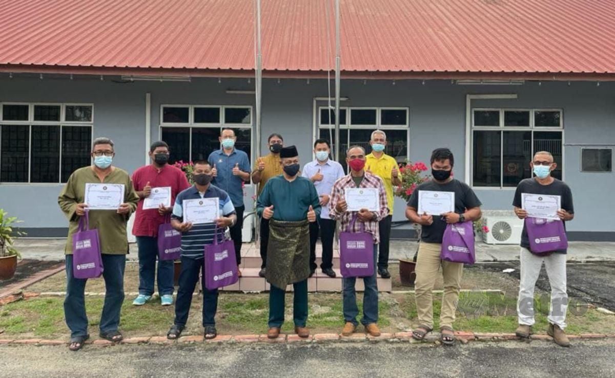 AZMI (tengah) menyerahkan semula wang tuntutan PSU kepada lapan pekerja yang layak. FOTO Ihsan SPRM Johor