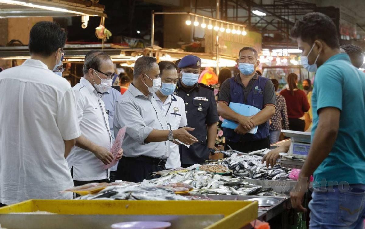 CHONG (tiga dari kiri) dan Mohd Hairul (empat dari kiri) ketika  pemeriksaan dan tinjauan barangan di Pasar Borong Pandan, Johor Bahru. FOTO Nur Aisyah Mazalan