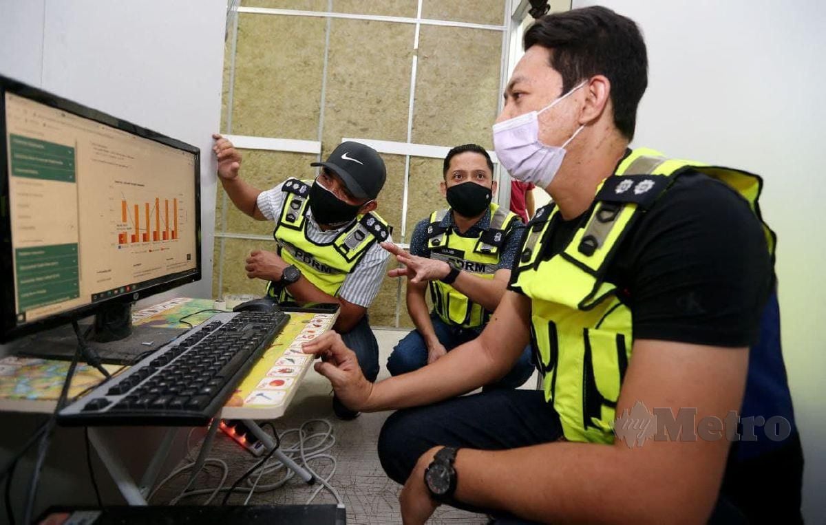 ANGGOTA polis merampas komputer yang digunakan bagi melombong mata wang digital Bitcoin. FOTO Mikail Ong