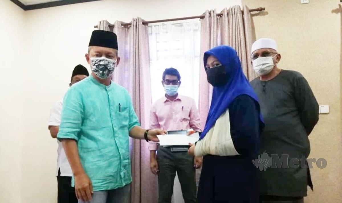 Pengerusi Lembaga Kemajuan Terengganu Tengah, Datuk Razali Idris (kiri) menyerahkan sebuah tablet kepada Damia Irdina Mohd Zuki. -FOTO ROSLI ILHAM