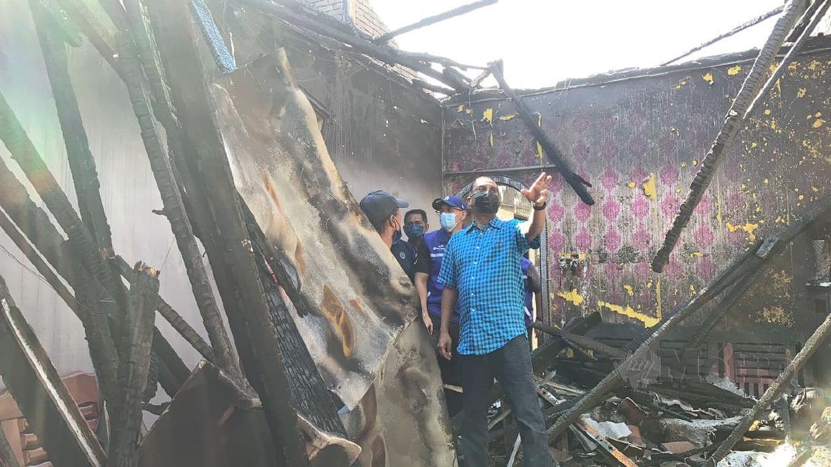 ZAMBRY (kanan) melawat rumah Amran (kiri) yang musnah dalam kebakaran di Fasa 2F, hari ini. FOTO NOOR HIDAYAH TANZIZI.
