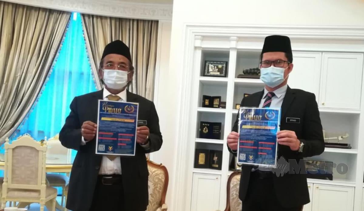 Ismail Othman (kiri) bersama Noor Effandi Ahmad menunjukkan risalah pertandingan pidato di Pejabat TYT Melaka, hari ini. FOTO AMIR MAMAT