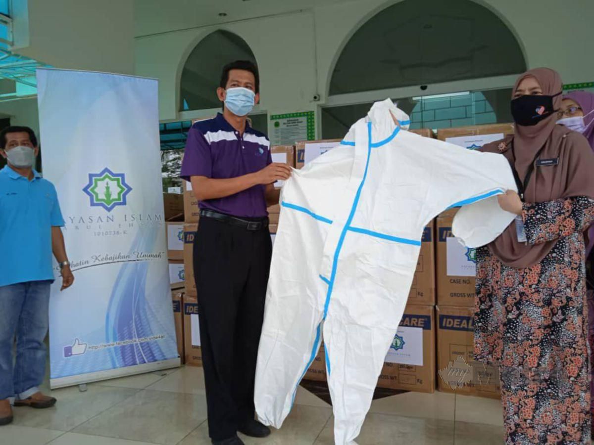 NUR Mohd Razali menyerahkan sumbangan 3,000 set PPE kepada Salwana. FOTO Ihsan Yide