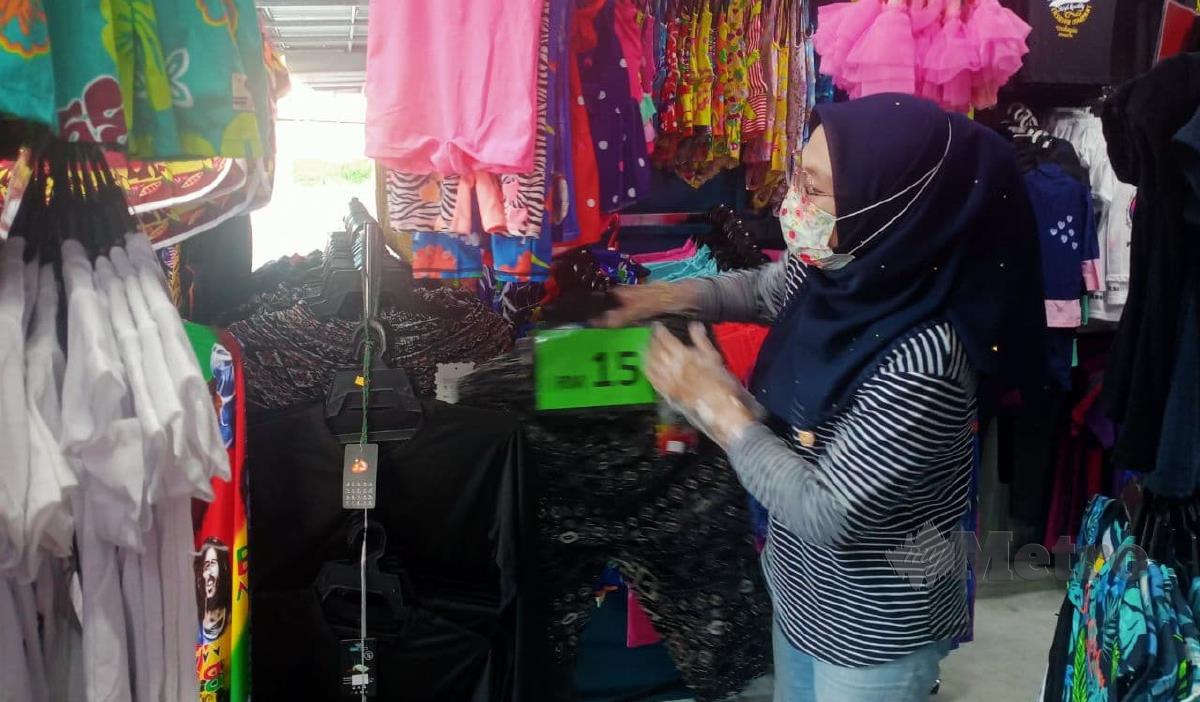 Wanie sedang memilih barangan yang baru dibeli daripada pembekal untuk persediaan memulakan kembali perniagaan di kawasan pantai Teluk Kemang, Port Dickson. FOTO MOHD KHIDIR ZAKARIA