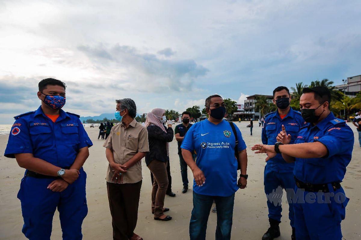 MUHAMMAD Sanusi (tengah) ketika meninjau Pantai Chenang. FOTO Luqman Hakim Zubir