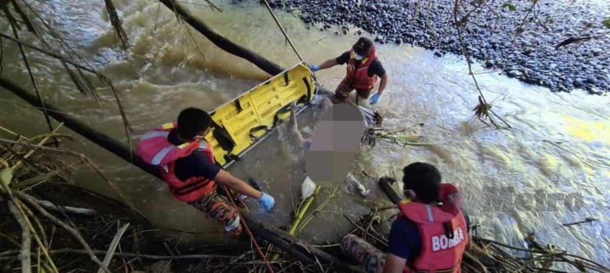 Anggota bomba mengusung mayat mangsa selepas ditemui tersangkut ditebint sungai.