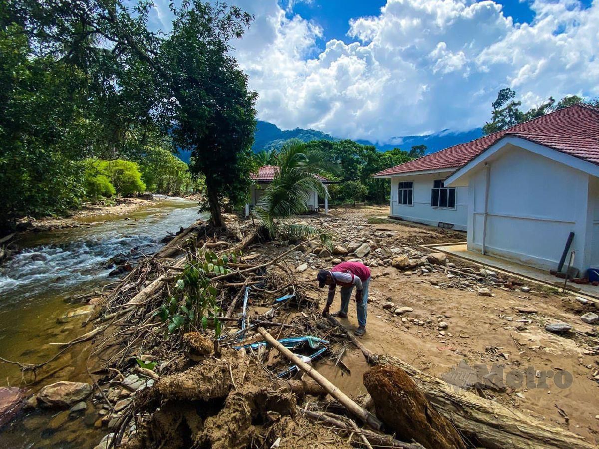 PENDUDUK membersihkan kawasan persekitaran rumah selepas dilanda banjir untuk kali kedua. FOTO Luqman Hakim Zubir