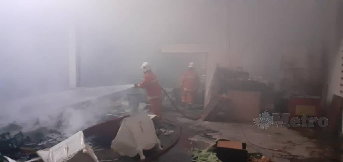 Anggota bomba memadam kebakaran membabitkan stor gudang menyimpan perabot di sebuah bangunan di Tasik Beris. FOTO IHSAN BOMBA