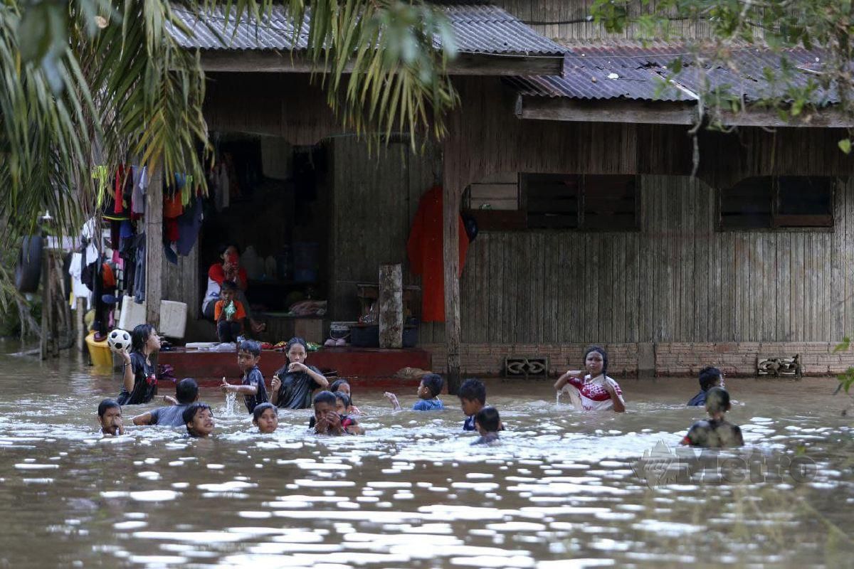 Penduduk bermain air di kawasan banjir. FOTO Nik Abdullah Nik Omar
