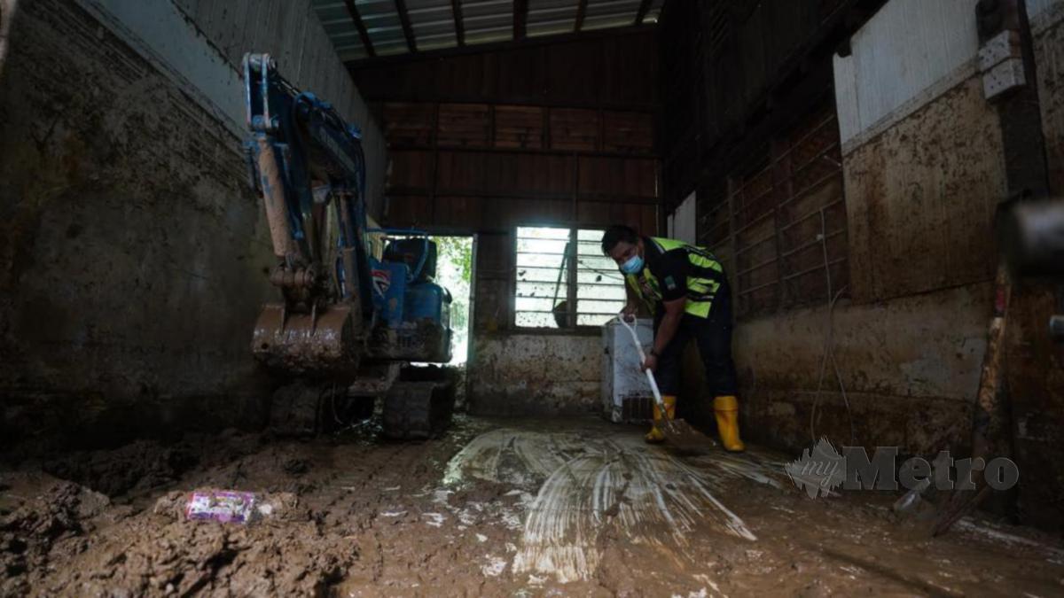 MOHAMAD Aiman Syafiq membersihkan rumah mangsa banjir ketika mengikuti aktiviti kesukarelawanan.