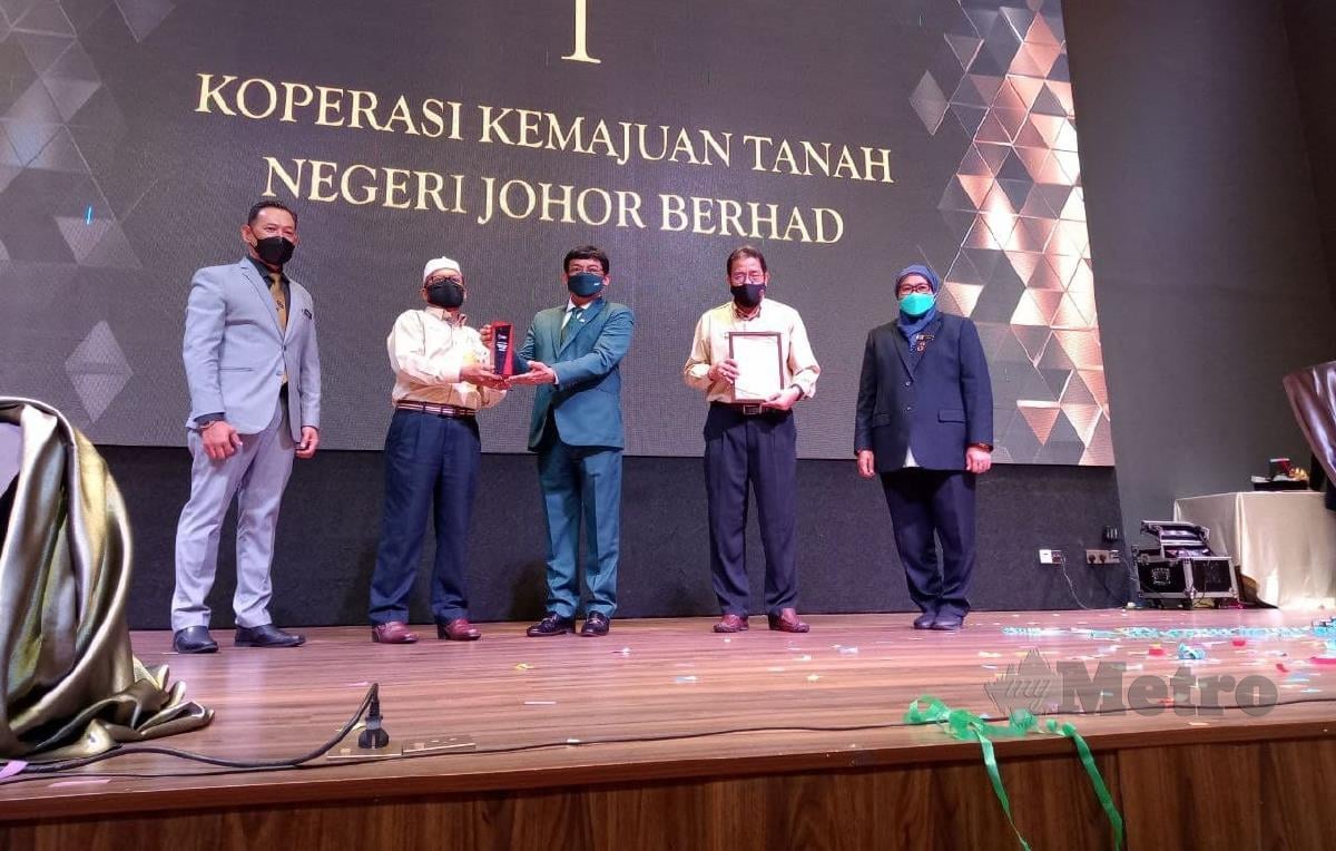 Izhar (tengah) menyampaikan kepada wakil Koperssi Kemajuan Tanah Negeri Johor Berhad yang mendapat tempat pertama dalam Anugerah 50 Koperasi Terbaik Negeri Johor 2020 di Hotel Throve. FOTO OMAR AHMAD