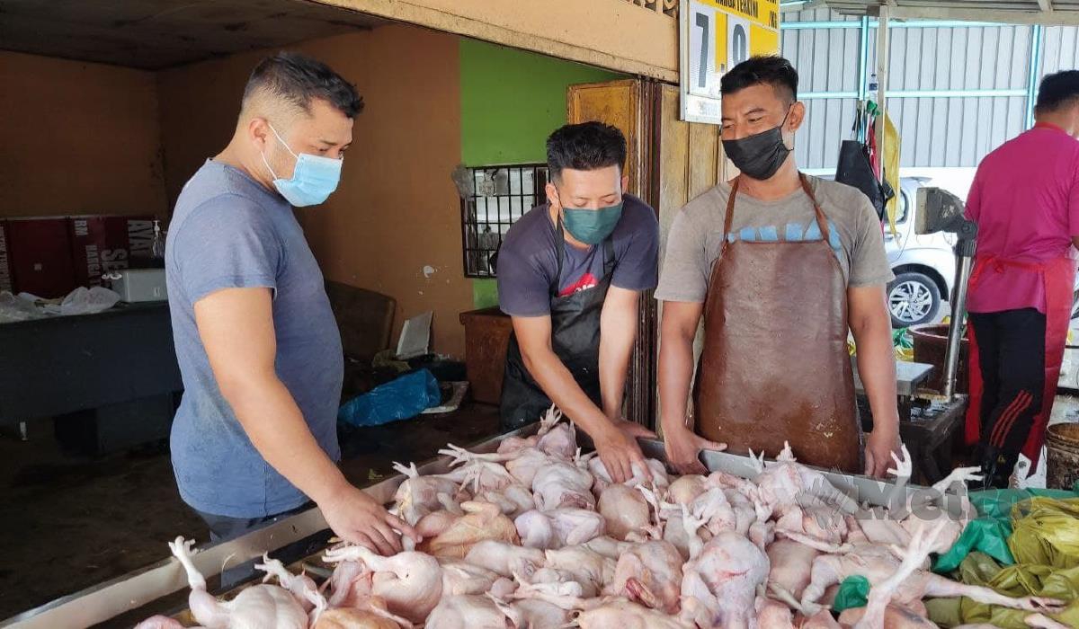 Azwan Che Mat (kiri) bersama rakan-rakannya menyusun bekalan ayam ketika ditemui di kedainya di Peringat. FOTO HIDAYATIDAYU RAZALI