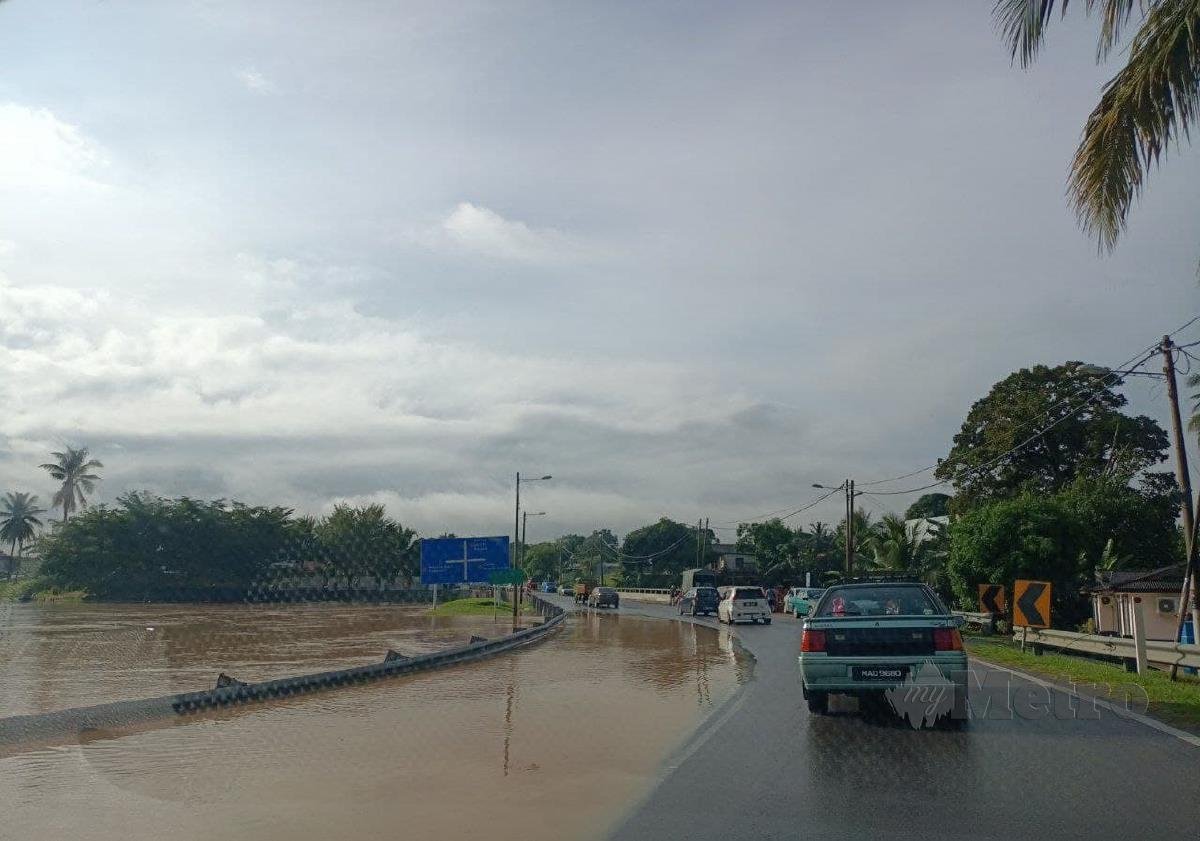 Sungai Pengkalan, Alor Gajah yang melimpah ke jalan raya yang turut menjejaskan penduduk kampung berkenaan. FOTO NAZRI ABU BAKAR