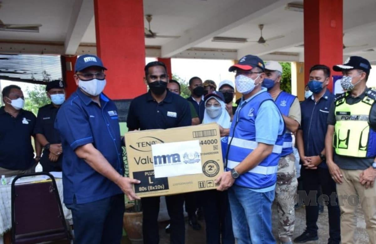 Wan Rosdy (kanan) menerima 200 kit berbentuk bantuan makanan kering serta barang sanitasi daripada Pengerusi Malaysia Medical Association (MMA) Bahagian Pengamal Perubatan Swasta, Dr Balachandran S Krishnan untuk diagihkan kepada mangsa banjir di daerah Jerantut. FOTO ROSELAN AB MALEK