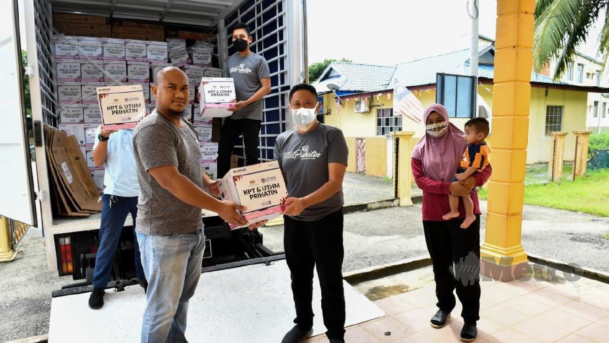 Wakil daripada UTHM menyerahkan sumbangan barang keperluan kepada mangsa banjir di Pahang. Foto Ihsan UTHM