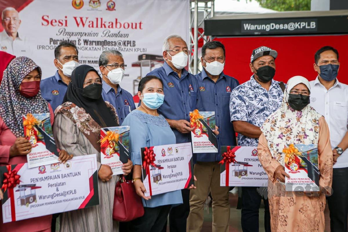 Mahdzir Khalid (tengah) bergambar dengan sebahagian penerima pada Majlis Penyerahan Peralatan Warung Desa di pejabat KEDA Kuala Nerang. FOTO LUQMAN HAKIM ZUBIR