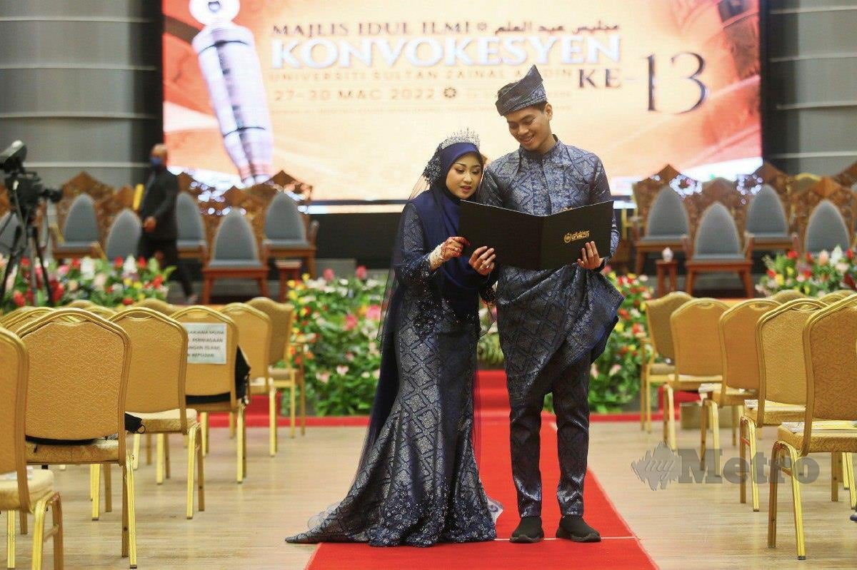 AMEERUL Hakim bersama isterinya, Nur Izzatul Nabilah lengkap berpakaian pengantin bergambar kenangan ketika Majlis Idul Ilmi Konvokesyen UniSZA  ke-13. FOTO Ghazali Kori