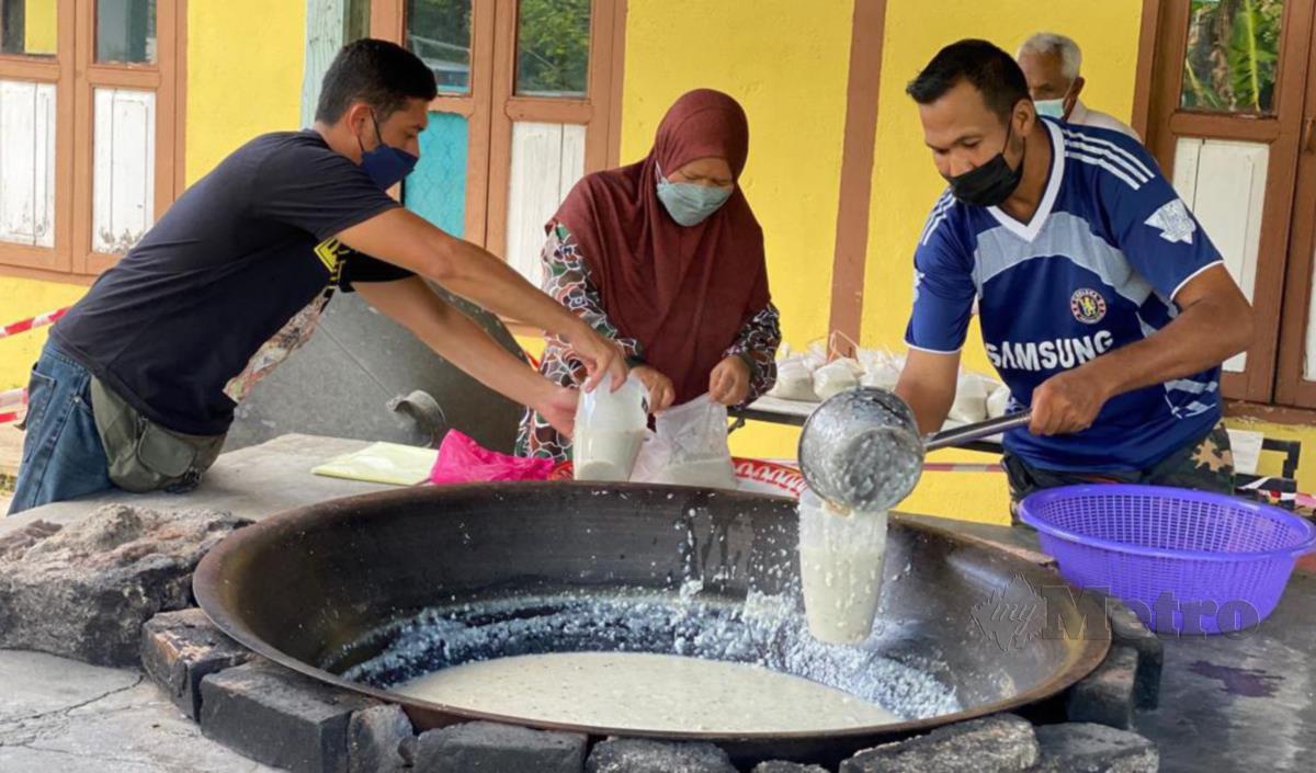 Penduduk Kampung Pulau Timbul melakukan gotong royong untuk menyediakan air halia dan bubur lambuk. FOTO Noorazura Abdul Rahman