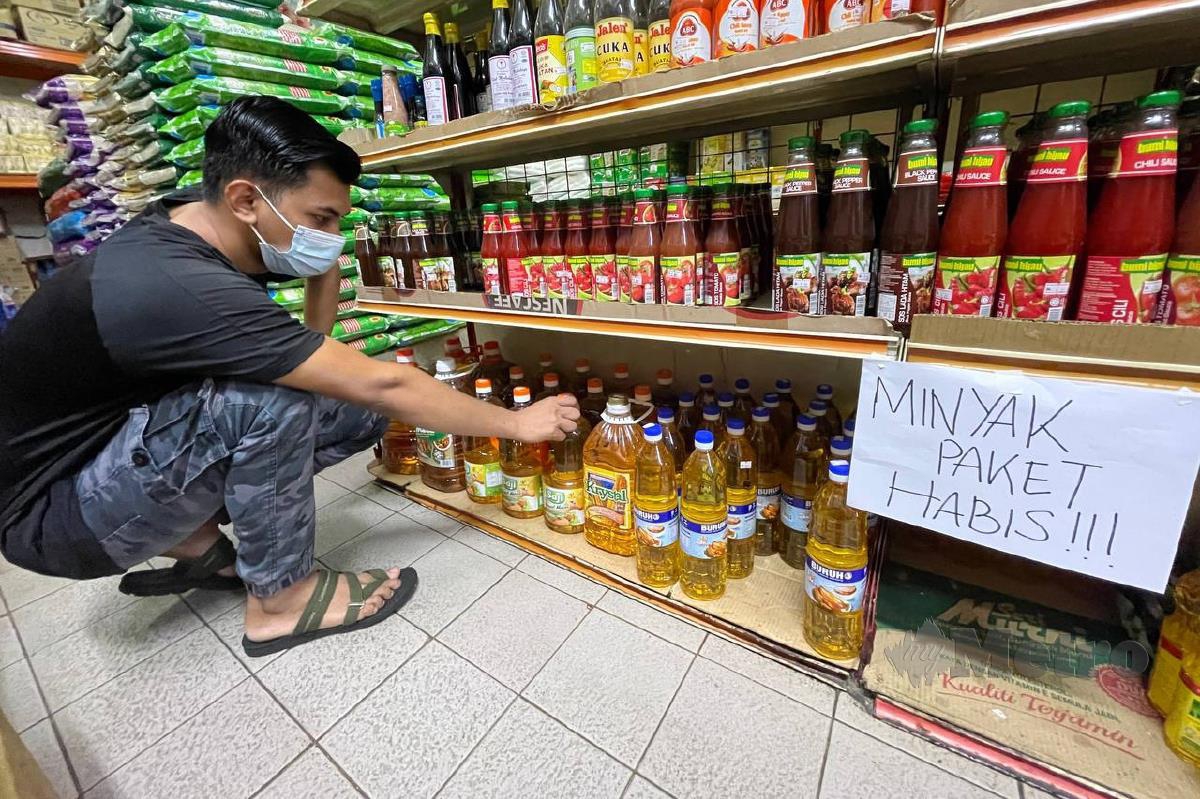 Peniaga, Jadirman menunjukkan ketiadaan stok minyak paket di kedainya di Taman Molek, Johor. FOTO NUR AISYAH MAZALAN