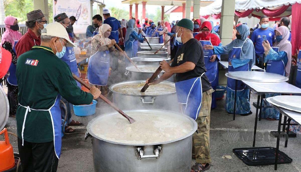 Penduduk kampung bergotong-royong memasak bubur lambuk pada Program Bubur Lambuk Perdana KPLB Bersama Titipan Kasih Harian Metro di Masjid Saiyidina Ali. FOTO SAIFULLIZAN TAMADI