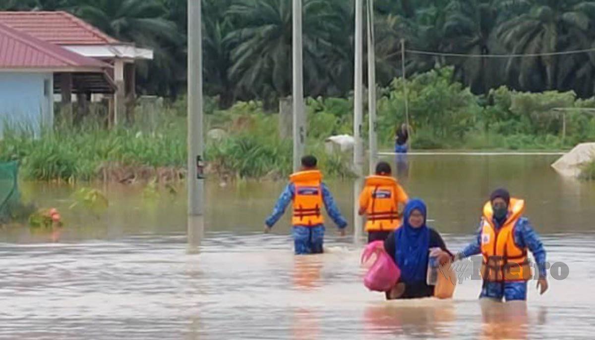 MANGSA banjir kilat di Kampung Sri Rahmat, Bukit Batu diselamatkan pasukan keselamatan. FOTO Ihsan Pembaca