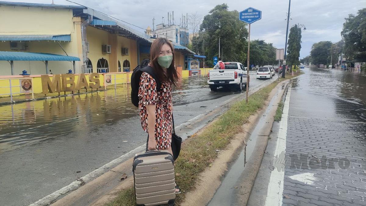 Pelancong dari Langkawi ke Kuala Kedah, Evon Lim, 46, terpaksa menunggu perkhidmatan motosikal disebabkan kawasan Kuala Kedah dipenuhi air akibat fenomena air pasang besar. FOTO ZULIATY ZULKIFFLI