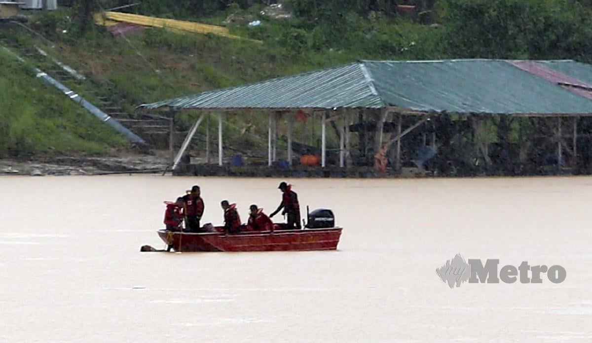 ANGGOTA bomba melakukan pencarian dengan bot di Sungai Kelantan. FOTO Nik Abdullah Nik Omar.