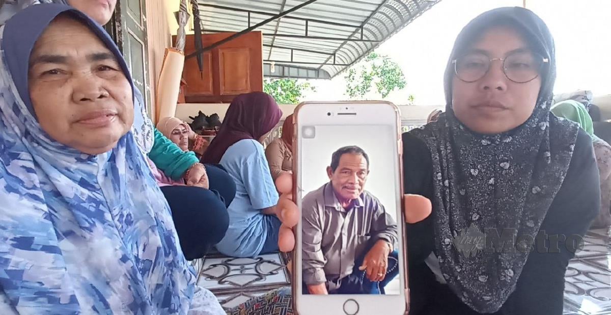 Tuan Nurul bersama ibu menunjukkan gambar bapanya. FOTO ZAID SALIM