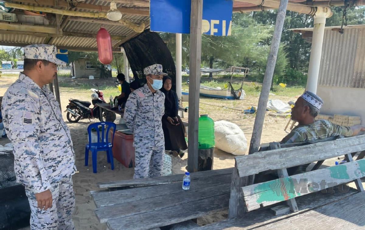 Mohd Zaki (duduk) mendengar penjelasan daripada pegawai APMM mengenai Ops Cari Lamat anaknya, Muhammad Farhin Yang dikhuatiri lemas selepas terjatuh daripada bot di Perairan Kuala Terengganu ketika pulang mencandat sotong, Sabtu lalu. FOTO ZAID SALIM