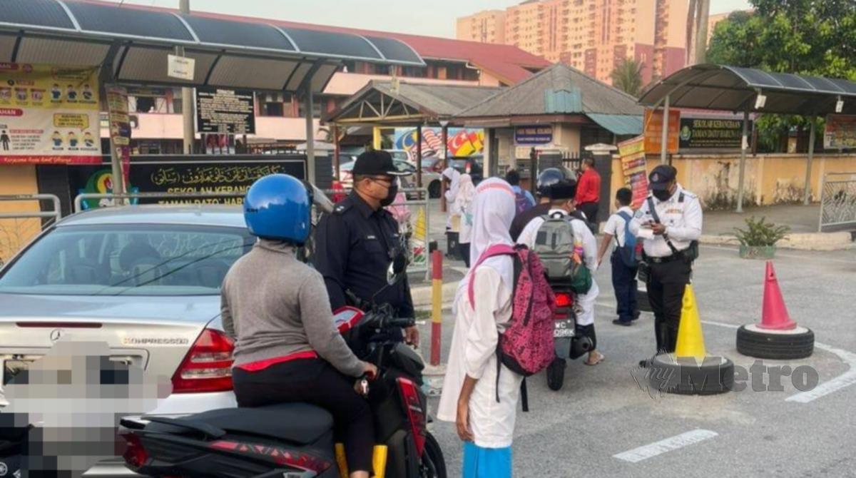 Polis memeriksa motosikal penduduk di sekitar Peraling Jaya.
