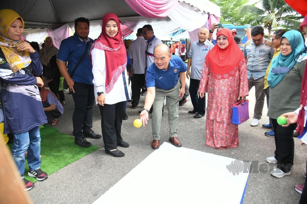 Sutekno (tengah) bersama ADUN Bukit Ibam mencuba permainan interaktif sempena dengan Hari Pengekalan Kepulihan Klien AADK di Felda Keratong 3, Rompin, Pahang.
