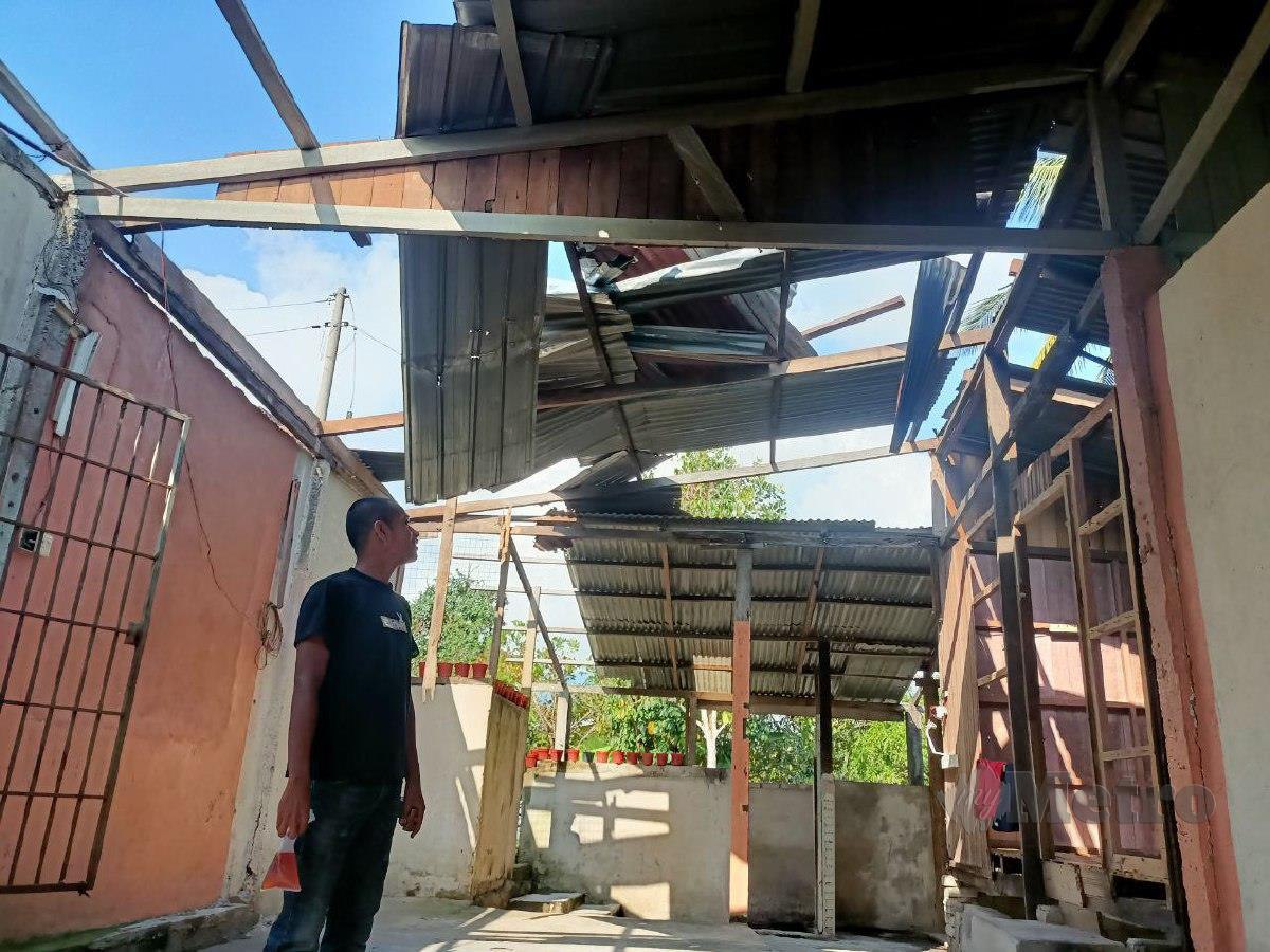 ANAS Ardi melihat sebahagian besar bumbung rumah pusaka yang didiaminya yang rosak akibat ribut. FOTO Siti Rohana Idris