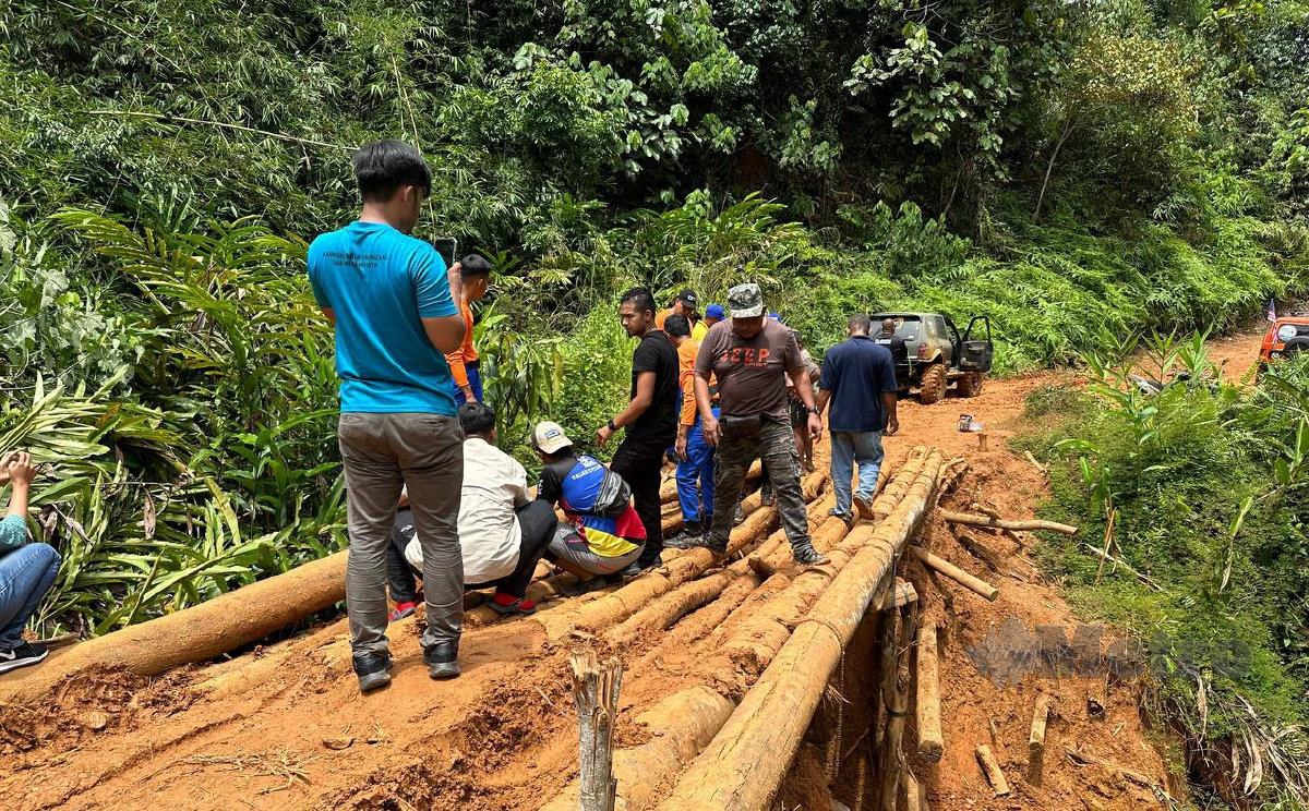 Peserta misi bergotong royong membaiki jambatan rosak bagi membolehkan melaluinya di Pos Gob. FOTO Paya Linda Yahya