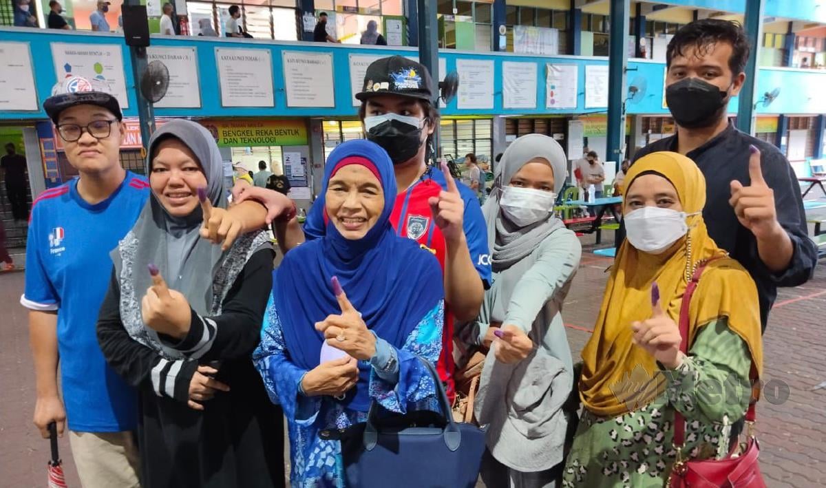Siti Zahrah bersama ahli keluarga mengundi di Sekolah Kebangsaan (SK) Taman Molek di sini hari ini. FOTO MARY VICTORIA DASS