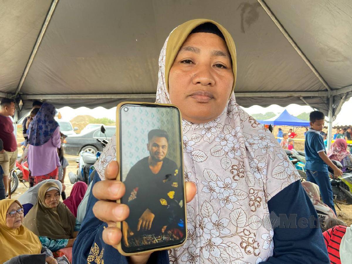 ROSLIZA menunjukkan gambar Muhammad Hisyamuddin yang dilaporkan hilang selepas bot pancung dinaiki bersama bapa saudara serta rakan karam. FOTO Hazira Ahmad Zaidi