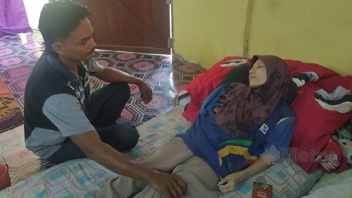 Mohd Nizam Ishak menemani isterinya, Norizan Abu Seman yang menghidap kanser payu dara di rumah mereka di Kampung Bukit Morai, Jalan Padang Pusing. FOTO ZULIATY ZULKIFFLI
