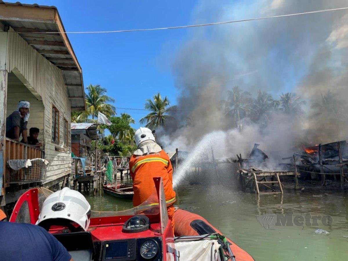 ANGGOTA bomba memadam kebakaran membabitkan lima rumah di Kampung Pulau Larapan Hujung. FOTO Ihsan Bomba
